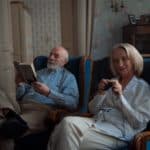 Deux retraités lisant un livre, assis sur des grands sièges